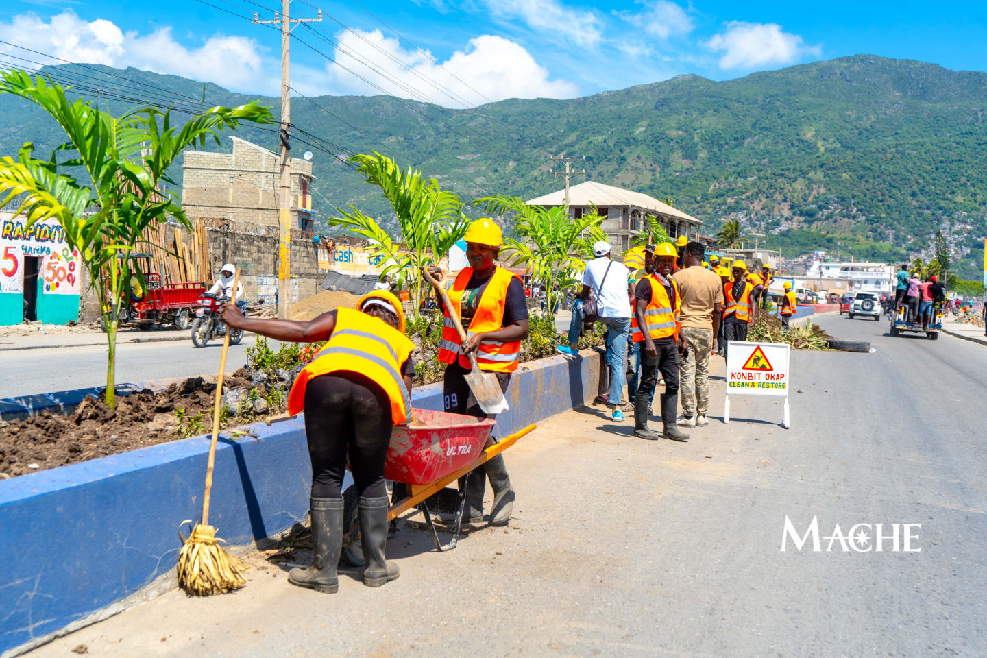 Konbit Okap · Clean & Restore sign posted along the active work zone.