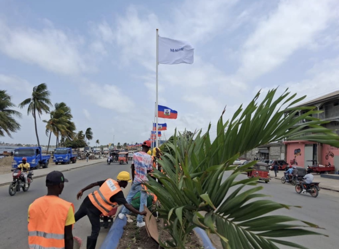 The MACHE flag raised over Cap-Haïtien — everyday work, national pride.