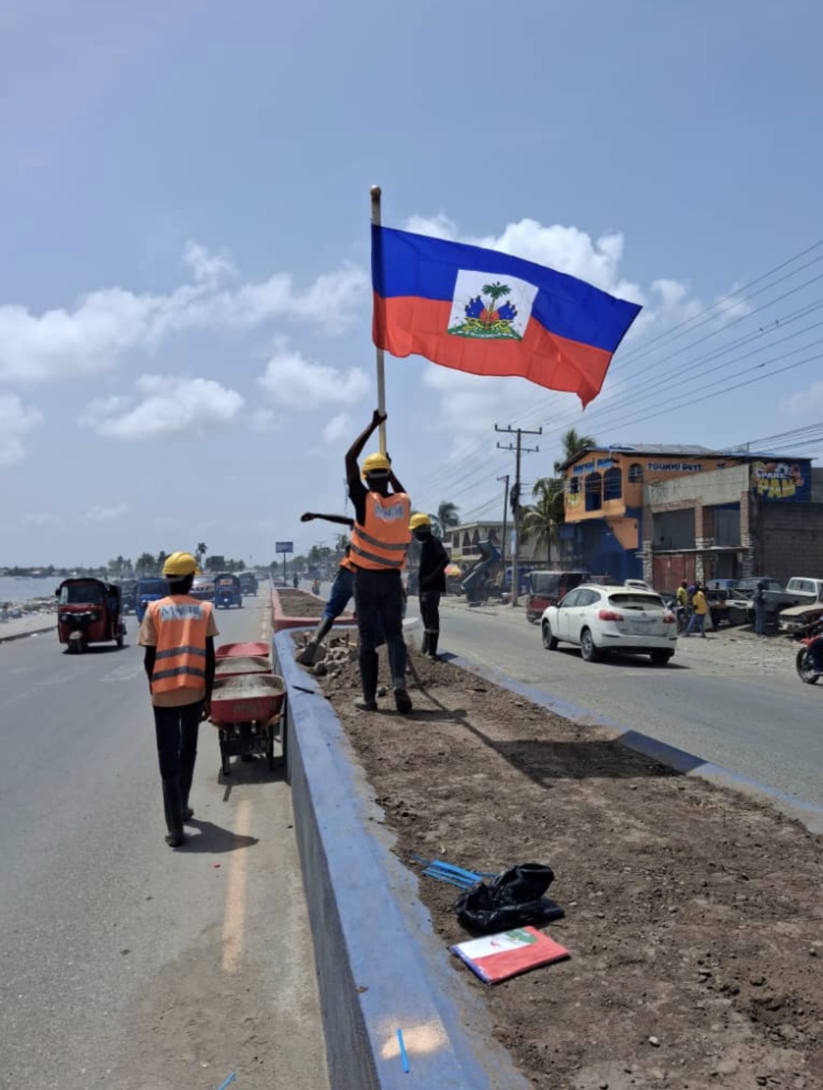 Raising the Haitian flag over the newly cleared boulevard.