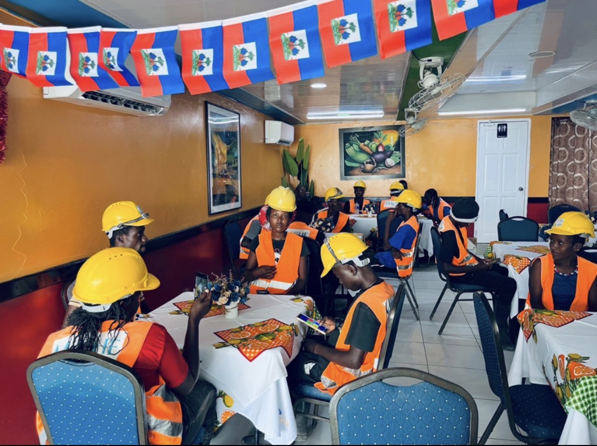 MACHE Community crews gathered — team meeting between shifts on the Cap-Haïtien restoration.
